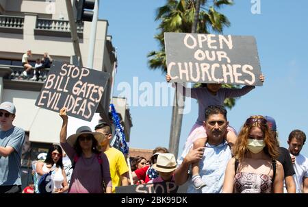 Huntington Beach, California, Stati Uniti. 1° maggio 2020. Una FATTURA DI STOP PORTA IDEE MALVAGIE e APRE LE NOSTRE CHIESE segni esposti, come parte di migliaia di persone si riuniscono all'angolo di Main Street e Pacific Coast Highway per protestare coronavirus (COVID-19) i dimostranti sono infelici circa le misure soggiorno a casa della California e il governatore di chiudere Orange County spiagge in particolare. Polizia montata a cavallo in linea in vigore all'ingresso della spiaggia e Huntington Beach Pier. Credit: Katrina Kochneva/ZUMA Wire/Alamy Live News Foto Stock