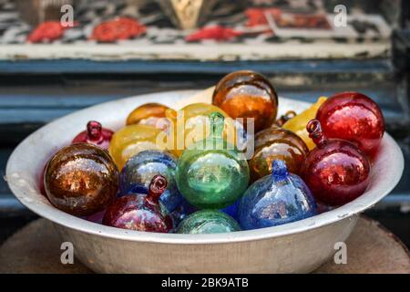 Baubles di vetro multicolore o palle di Natale venduti in strada di fronte ad un negozio di souvenir ad Amsterdam, Paesi Bassi Foto Stock