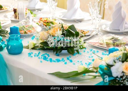 Bouquet di rose e decorazioni turchesi sul tavolo da nozze Foto Stock