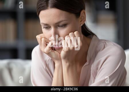 Primo piano su sconvolto giovane donna pensando solo ai problemi Foto Stock