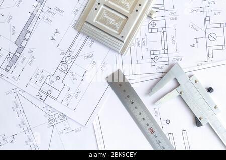 Vista dall'alto di uno strumento di misurazione calibro, righello e disegni di dettaglio.disegni tecnici, dettagli metallici. Foto Stock