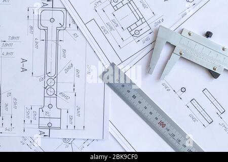 Vista dall'alto di uno strumento di misurazione calibro, righello e disegni di dettaglio.disegni tecnici, dettagli metallici. Foto Stock