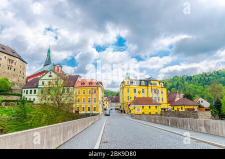 Loket, Repubblica Ceca, 12 maggio 2019: ponte sul fiume Eger, città con il castello di Loket Hrad Loket stile gotico su roccia massiccia e colorati edifici, Karlovy Vary Regione, Boemia occidentale Foto Stock