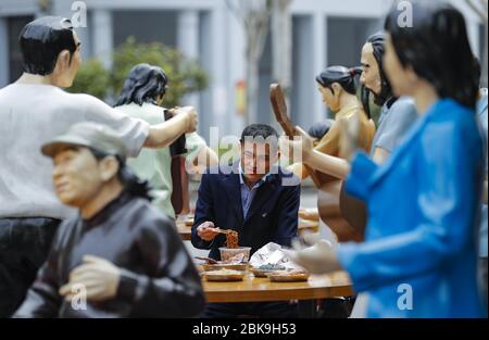 Pechino, provincia cinese di Hubei. 5 Aprile 2020. Un uomo ha un pasto accanto alle statue in un ristorante all'aperto a Wuhan, nella provincia di Hubei della Cina centrale, il 5 aprile 2020. Credit: Shen Bohan/Xinhua/Alamy Live News Foto Stock