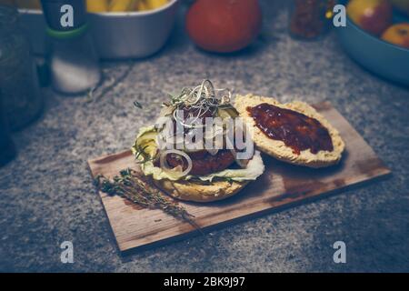 Hamburger vegano fatto in casa con barbecue e cipolle su piastra di legno Foto Stock