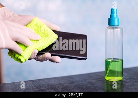 un uomo schizza su un panno da un igienizzatore per disinfettare e prevenire le malattie virali. Agente antibatterico antimicrobico per l'uccisione di microbi. Pulizia di un Foto Stock