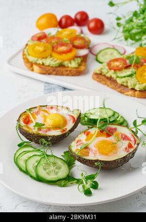 uova cotte in avocado, toast, colazione, primo piano Foto Stock