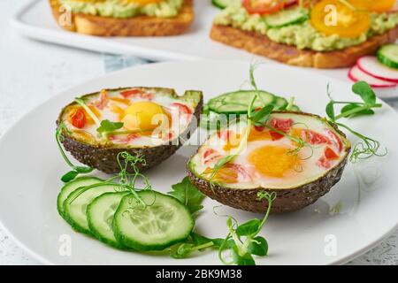 uova cotte in avocado, toast, colazione, primo piano Foto Stock