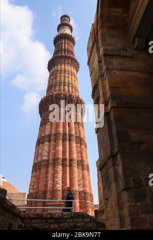 La sua vista diffidente di Qutub Minar. Il minareto più alto dell'India è una torre in marmo e arenaria rossa che rappresenta l'inizio del dominio musulmano nel Foto Stock