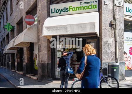 Cremona, Lombardia, Italia - 2020 maggio le persone si accodano fuori dalla farmacia Lloyds , le persone si sono messe in coda per entrare una volta per volta, in quanto si applicano nuove regole Foto Stock