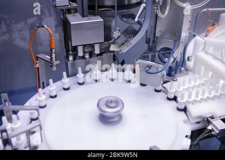 Un uomo lavora in una fabbrica farmaceutica. Monitoraggio visivo della qualità della produzione di interferone. Linea di produzione di ormoni sterili. Foto Stock