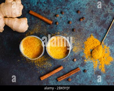Vista dall'alto del latte curcuma, zenzero, cannella e allspezia. Bevanda immune e sanitaria. Foto Stock