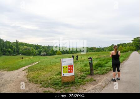 Hampstead Heath e London skyline, con istruzioni illustrate durante la pandemia di Covid-19. La gente cammina e corre osservando le distanze sociali. Foto Stock