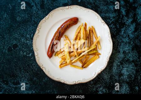 Salsiccia fatta in casa con patate Skinny French Fries in piatto chiamato anche salchipapa peruviana. Fast food. Foto Stock