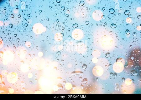 gocce d'acqua sulla finestra di vetro con luci bokeh Foto Stock