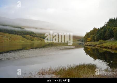 La mattina presto si innalza la nebbia in autunno al Parco Nazionale di Loch Lubbhair Trossachs, Scozia Foto Stock