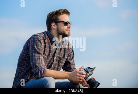 Fotografo hipster. Blogger tiro vlog. Bella blogger ragazzo viaggiatore telecamera retro. Impostazioni manuali. Blogger di viaggio. Ragazzo all'aperto cielo blu sfondo. Attrezzature d'epoca. Reporter scattare foto. Foto Stock