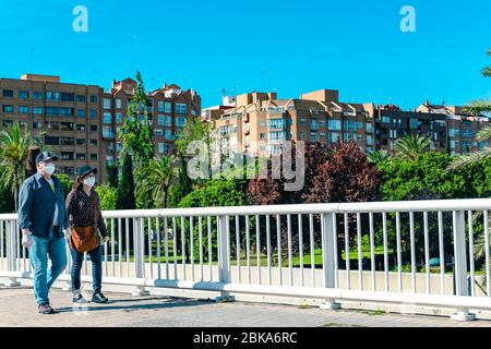 Valencia, Spagna, 02 maggio 2020: Coppia di mezza età, indossando maschere mediche e guanti bianchi durante la loro passeggiata al parco. Covid-19 o Coronavirus inf Foto Stock