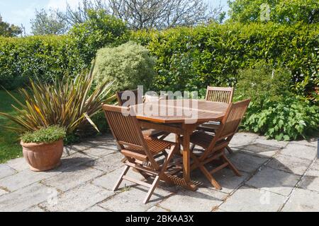 Terrazza e mobili da giardino in legno in un giardino durante la primavera Foto Stock