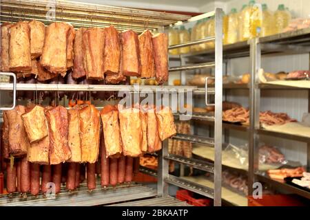 Un lavoratore della fabbrica di lavorazione della carne prepara le salsicce al tavolo di lavoro. Industria alimentare e di trasformazione. Miscela di carne cruda: Bistecche, pollame Foto Stock