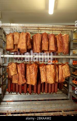 Un lavoratore della fabbrica di lavorazione della carne prepara le salsicce al tavolo di lavoro. Industria alimentare e di trasformazione. Miscela di carne cruda: Bistecche, pollame Foto Stock
