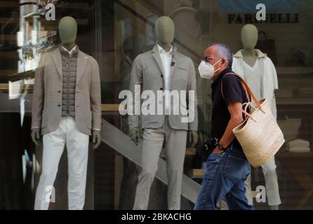 Palma, Spagna. 02 maggio 2020. Un uomo con una guardia della bocca cammina davanti ad un negozio nel centro di Palma de Mallorca. Dopo quasi 50 giorni di stretta quarantena durante la crisi di Corona nelle loro case, le persone stanno effondendo all'aria aperta entro i loro orari assegnati e entro le distanze di sicurezza. Credit: Clara Margais/dpa/Alamy Live News Foto Stock