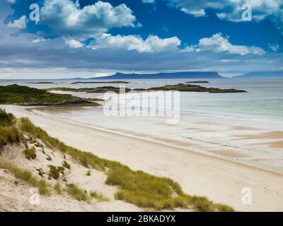 Con le isole di Eigg e Rum all'orizzonte, una vista attraverso la spiaggia di Camusdarach sulla costa occidentale della Scozia - la spiaggia apparsa nel film locale Foto Stock