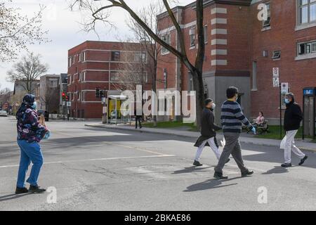 Pedoni che indossano maschere facciali nel quartiere immigrato di estensione parco, Coronavirus Pandemic Foto Stock