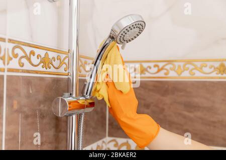 Pulizia del rubinetto dal calcare in bagno, disinfezione della superficie da contaminazione Foto Stock