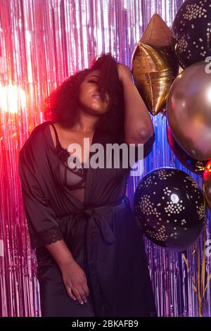 Bella donna nera godendo di uno stile di vita party. Festa di compleanno, clubbing e concetto di vacanze. Foto Stock
