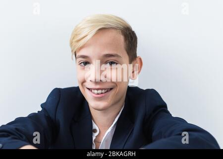 Primo piano di ragazzo teen con le bretelle sui denti sorridente su sfondo bianco. Odontoiatria e teenager concetto. Foto Stock