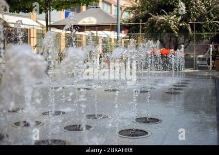 Spruzzi d'acqua da una fontana in estate in città Foto Stock