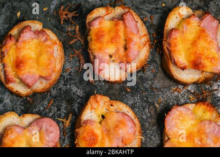 Panini al forno con salsiccia e formaggio. Primo piano dei piccoli panini preparati Foto Stock