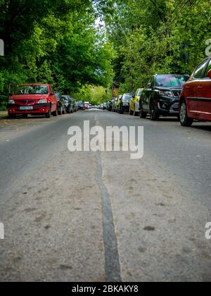 Bucarest/Romania - 05.01.2020: La carta parcheggiata su entrambi i lati di una strada che la rende molto stretta e difficile da guidare. Strada con auto e un sacco di gr Foto Stock