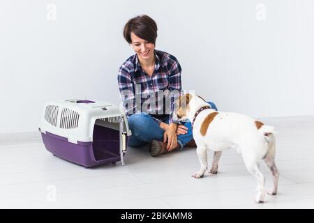 Concetto proprietario di animali domestici - attraente ragazza allegra in camicia a quadri tiene l'animale domestico favorito. Felice donna con il suo jack russell terrier Foto Stock