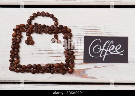 Quadrato di chicchi di caffè su legno bianco. Foto Stock