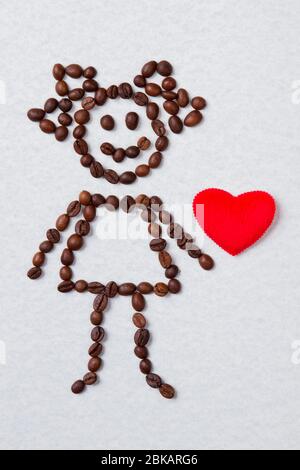 Ragazza fatta di chicchi di caffè e cuore rosso. Foto Stock
