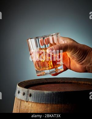 bicchiere di whisky in mano umana Foto Stock