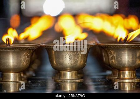 Lampade a fuoco in un tempio buddista a Thimphu, Bhutan Foto Stock