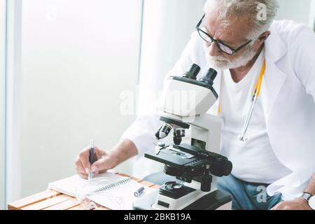 Medico professionista scienziato di lavoro ricerca nuovo vaccino e virus e scrittura di nota relazione presso il laboratorio ospedaliero. Foto Stock