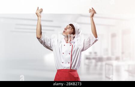Giovane chef maschile con un cartello bianco vuoto Foto Stock
