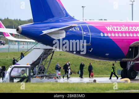 La foto del 1° maggio mostra i passeggeri che lasciano l'aereo dopo l'arrivo sul primo aeromobile Wizz Air per atterrare a Londra Luton il venerdì a pranzo dopo che la compagnia aerea ha ripreso i voli di oggi. I passeggeri che indossavano maschere facciali sono stati visti a bordo di un aereo Wizz Air a Londra Luton questo pomeriggio (venerdì), mentre la compagnia aerea ungherese a basso costo ha ripreso i voli per le destinazioni europee. Si sono tenuti a due metri di distanza quando hanno effettuato il check-in per il volo verso Sofia in Bulgaria alle 13:30 e la maggior parte, ma non tutti, hanno mantenuto la loro distanza l'uno dall'altro mentre si sono imbarcati. Altri passeggeri sono stati visti prima sbarcare dall'aereo, Foto Stock