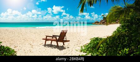 Palm e spiaggia tropicale. Vacanze vacanze viaggio concetto panorama sfondo carta parati. Sedie sulla spiaggia di sabbia vicino al mare. Vacanze estive e va Foto Stock