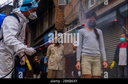 Kathmandu, Nepal. 3 maggio 2020. Un bambino che viene spruzzato con disinfettante come precauzione contro la diffusione di coronavirus durante la pandemic.Local residenti volontariato nella loro comunità di disinfettare i compagni residenti in mezzo alla situazione nazionale di blocco e di minaccia del virus corona. Credit: Sunil Pradhan/SOPA Images/ZUMA Wire/Alamy Live News Foto Stock