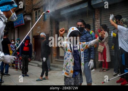 Kathmandu, Nepal. 3 maggio 2020. Un bambino che viene spruzzato con disinfettante come precauzione contro la diffusione di coronavirus durante la pandemic.Local residenti volontariato nella loro comunità di disinfettare i compagni residenti in mezzo alla situazione nazionale di blocco e di minaccia del virus corona. Credit: Sunil Pradhan/SOPA Images/ZUMA Wire/Alamy Live News Foto Stock