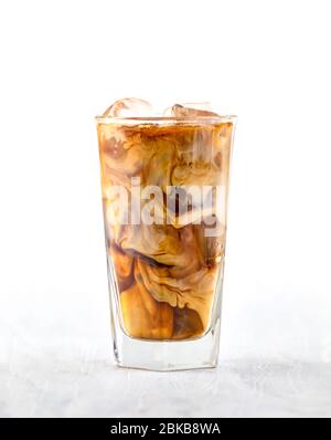 bicchiere di caffè ghiacciato con latte su tavolo di legno bianco Foto Stock