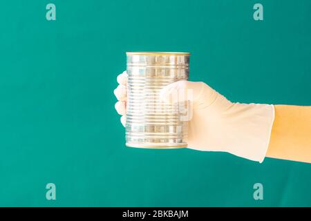 Guanti di gomma bianca per tenere in mano cibo in scatola. Coronavirus. Spazio di copia. Foto Stock