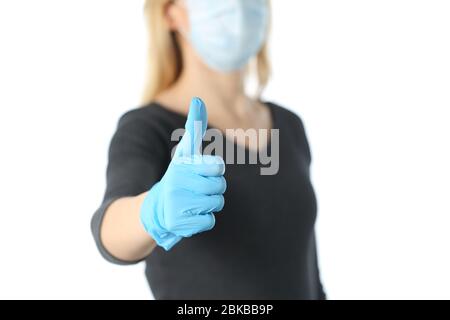 Primo piano della mano donna che gesture pollici su evitando coronavirus con maschera e guanti isolati su sfondo bianco Foto Stock