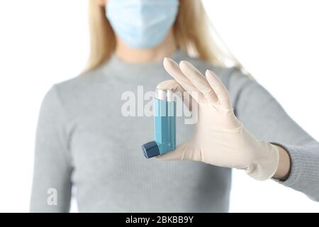 Vista frontale ravvicinata della mano della donna che mostra l'inalatore evitando il covid-19 con maschera e guanto isolati su sfondo bianco Foto Stock