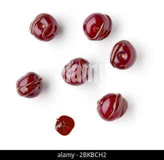 ciliegie acide ricoperte di cioccolato fuso isolate su sfondo bianco, vista dall'alto Foto Stock